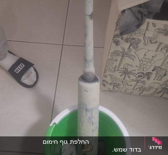 מגב ודלי ירוק על רצפה